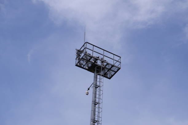 Tall camera tower at night with LED floodlights activated